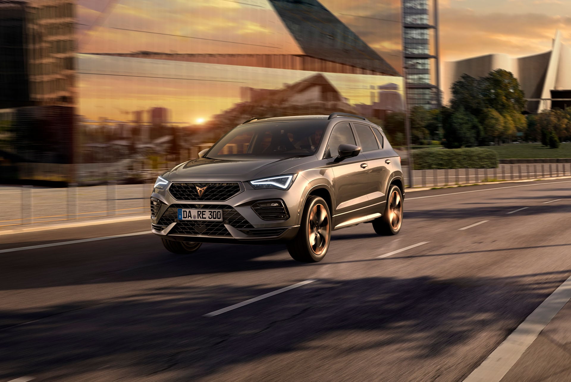 Ein grauer CUPRA Ateca SUV. Das Fahrzeug zeichnet sich durch einen markanten Frontgrill, LED-Scheinwerfer und Leichtmetallfelgen mit Kupferakzenten aus, die das sportliche Design des Autos betonen.