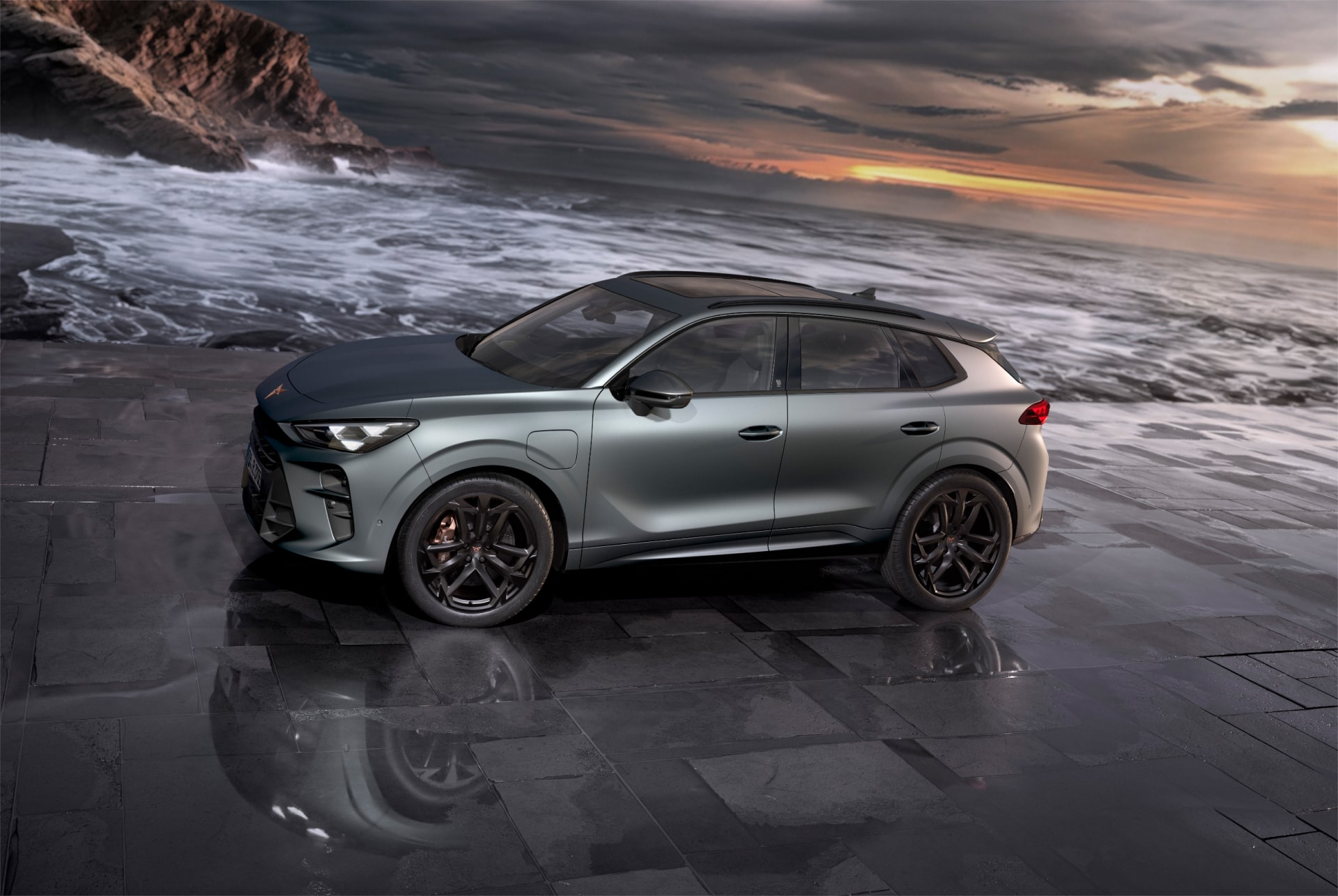 cupra terramar hybrid suv, neues modell 2024, seitenansicht, mit 20-zoll-leichtmetallfelgen von america's cup und akebono-bremsen, enceladusgrau matt, auf nassem pflaster am meer bei sonnenuntergang.